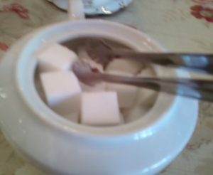How to reduce sugar consumption? Sugar cubes in a white sugar pot.
