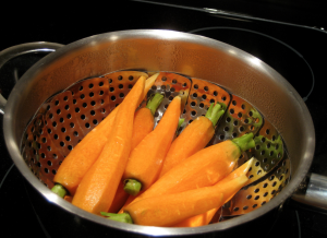 How Long To Boil Carrots, eight carrots in a metal strainer.