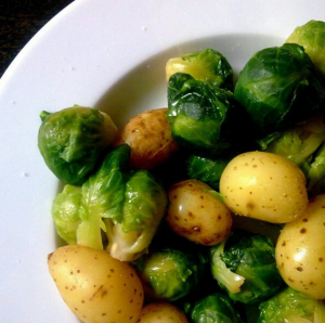 How Long Does It Take To Boil Potatoes, a white plate of boiled potatoes and sprouts.